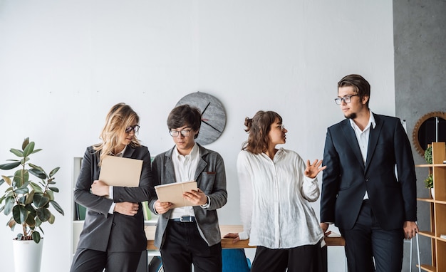 Die Geschäftsleute, die im Büro stehen, besprechen sich