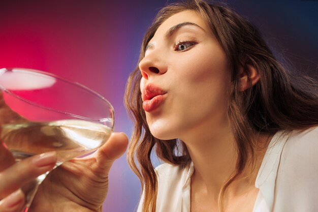 Die glückliche junge Frau. Emotionales weibliches süßes Gesicht. Blick aus dem Glas