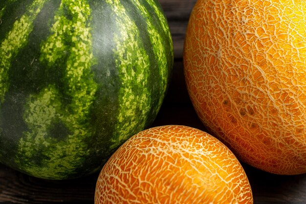 Die grüne Runde der grünen Wassermelone der Vorderansicht bildete frische und saftige Früchte mit Melonen auf dem braunen Schreibtisch