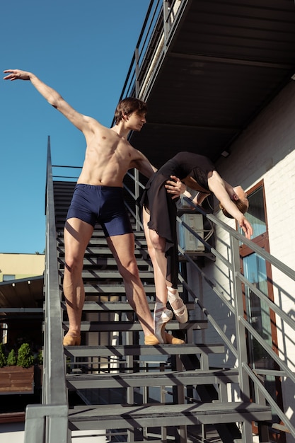 Die Gruppe der modernen Balletttänzer, die auf der Treppe in der Stadt auftreten