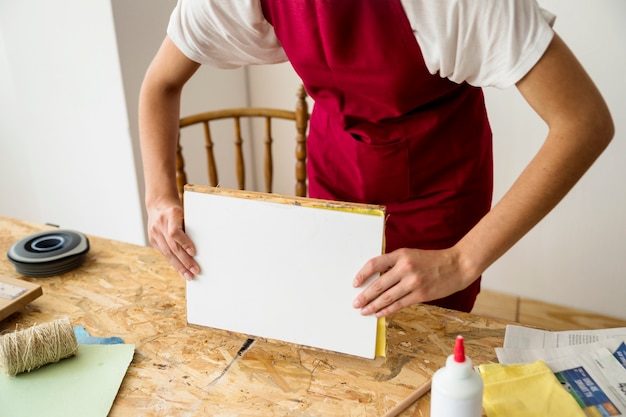 Die Hand der Frau, die Form über hölzernem Schreibtisch hält