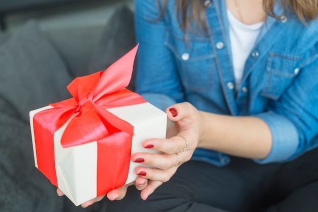 Kostenloses Foto die hand der frau, die geschenk hält