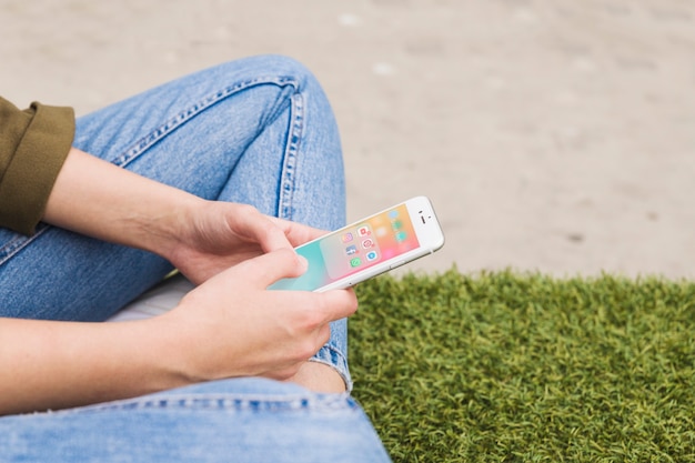 Kostenloses Foto die hand der frau, die mobiltelefon unter verwendung der social media-anwendung hält