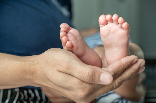 Die Hand der Mutter zierte die Füße des Neugeborenen.