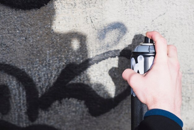 Die Hand des Mannes, die Graffiti mit Spray macht