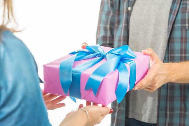 Die Hand des Mannes, die seiner Freundin Valentinsgrußgeschenk gibt