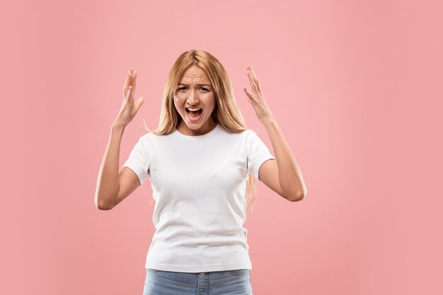 Die junge emotionale wütende Frau, die im Studio schreit