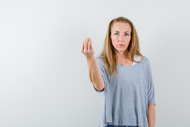 Die junge Frau zeigt köstliche Geste mit der Hand auf weißem Hintergrund