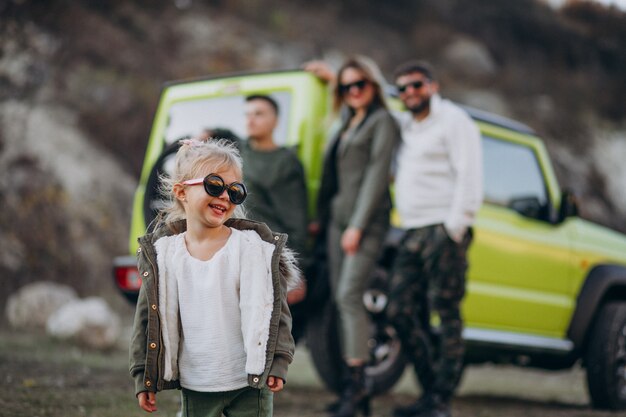 Die junge moderne Familie, die mit dem Auto reist und hielt für einen Spaziergang im Park an