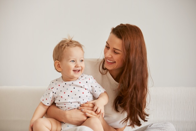 Die junge Mutter mit ihrem einjährigen kleinen Sohn im Pyjama entspannt sich