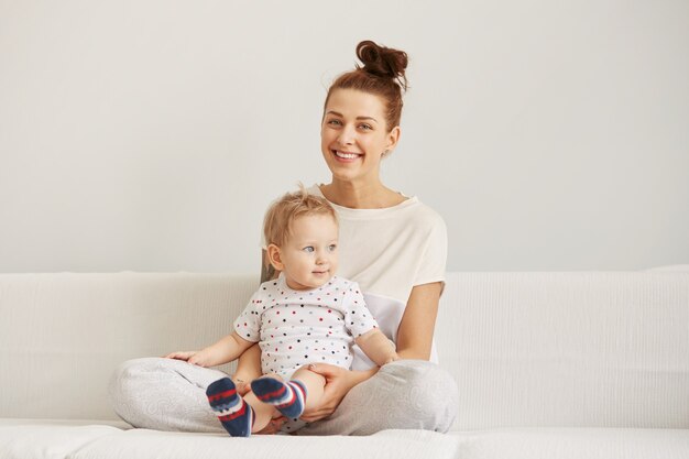 Die junge Mutter mit ihrem einjährigen kleinen Sohn im Pyjama entspannt sich