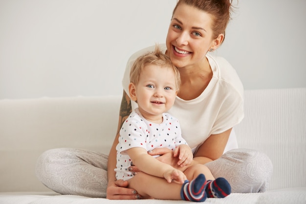 Die junge Mutter mit ihrem einjährigen kleinen Sohn im Pyjama entspannt sich