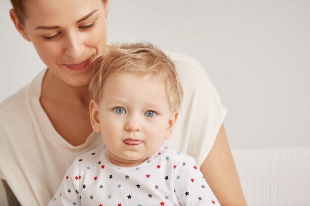 Die junge Mutter mit ihrem einjährigen kleinen Sohn im Pyjama entspannt sich