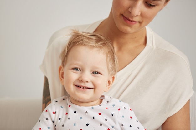 Die junge Mutter mit ihrem einjährigen kleinen Sohn im Pyjama entspannt sich