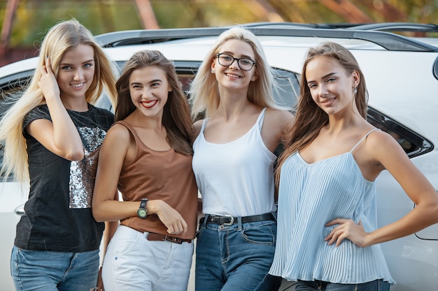 Die jungen Frauen stehen in der Nähe des Autos