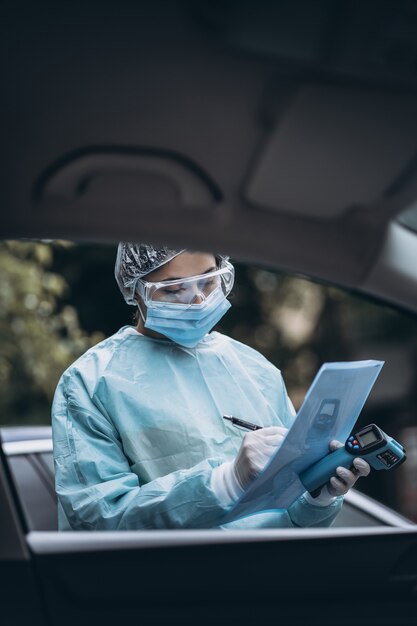 Die Krankenschwester trägt während des COVID19-Ausbruchs einen Schutzanzug und eine Maske.