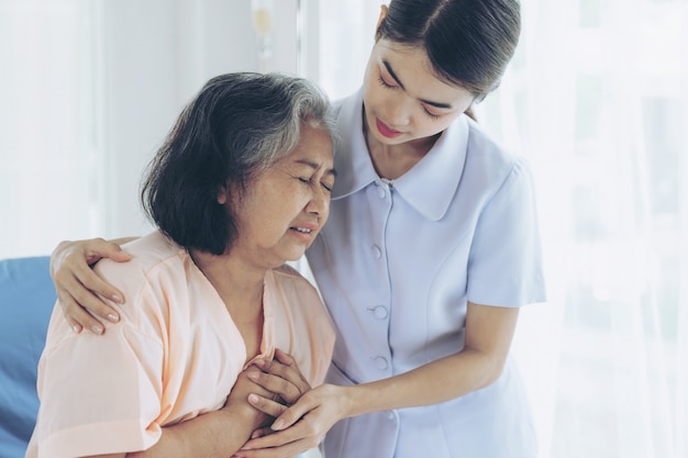 Die Krankenschwestern kümmern sich gut um ältere Patientinnen in Krankenhausbettpatienten