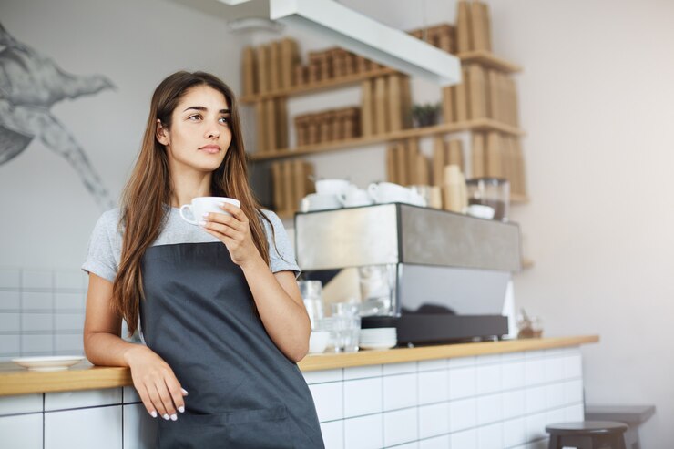 Kostenlose Foto die ladenbesitzerin macht eine pause von ihrer arbeit als barista und träumt von einem größeren geschäft