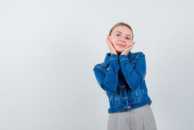 Die lächelnde blonde Frau hält ihre Hände unter dem Kinn auf weißem Hintergrund