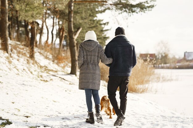 Die Leute gehen nach draußen. Wintertag. Afrikanisches Paar mit Hund.