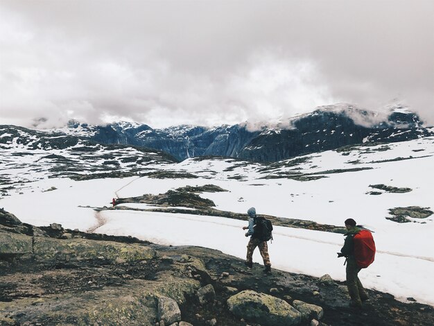 Die Leute laufen über die mit Schnee bedeckten Berge