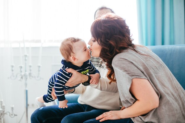 Die Mutter, der Vater und der Sohn, die auf dem Sofa sitzen