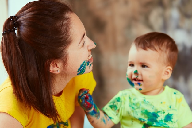 Die Mutter mit dem Sohn, der ein großes Papier mit ihren Händen malt