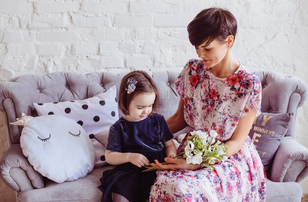 Die Mutter mit der Tochter, die auf dem Sofa sitzt