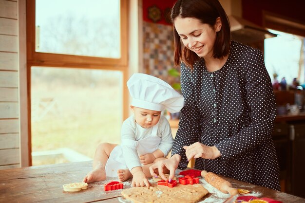 Die Mutter mit Sohn knetet den Teig in der Küche