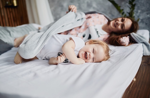 Die Mutter mit Tochter liegt auf dem Bett