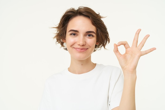 Kostenloses Foto die nahaufnahme einer lächelnden, glücklichen jungen frau zeigt, dass die geste „null okay, ok“ etwas gutes befürwortet