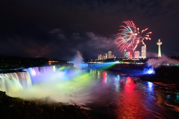 Die Niagarafälle werden nachts von bunten Lichtern mit Feuerwerk beleuchtet