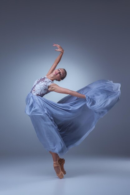 Die schöne Ballerina tanzt im blauen langen Kleid