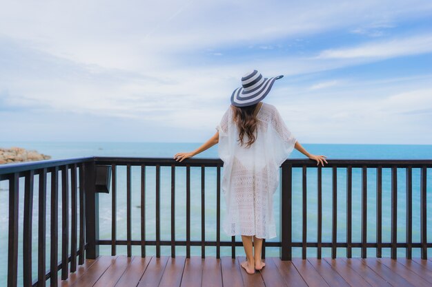 Die schöne junge asiatische Frau des Porträts, die Seestrandozean sucht, entspannen sich in der Urlaubsreise