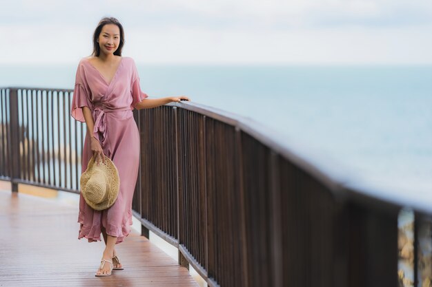 Die schöne junge asiatische Frau des Porträts, die Seestrandozean sucht, entspannen sich in der Urlaubsreise