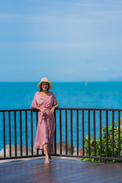 Die schöne junge asiatische Frau des Porträts, die Seestrandozean sucht, entspannen sich in der Urlaubsreise