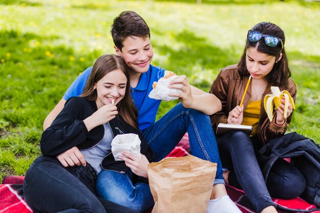 Die Schüler essen auf dem Gras