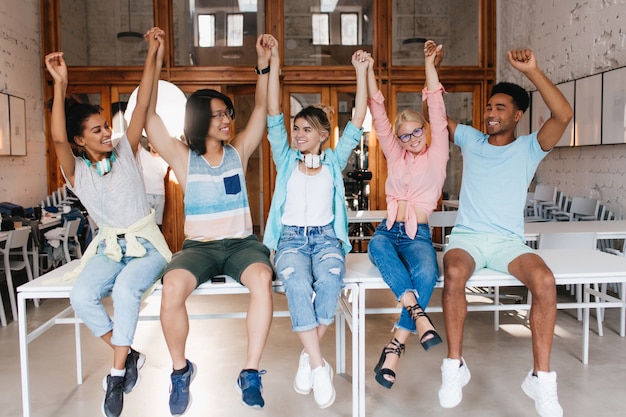 Die Schüler gratulieren einander zum Ende des Schuljahres. Universitätsfreunde sind froh, dass sie die Abschlussprüfungen erfolgreich bestanden haben und mit den Händen winken.