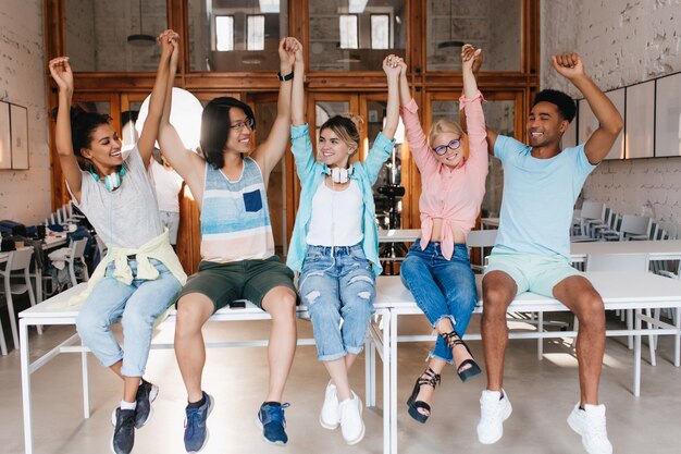 Die Schüler gratulieren einander zum Ende des Schuljahres. Universitätsfreunde sind froh, dass sie die Abschlussprüfungen erfolgreich bestanden haben und mit den Händen winken.