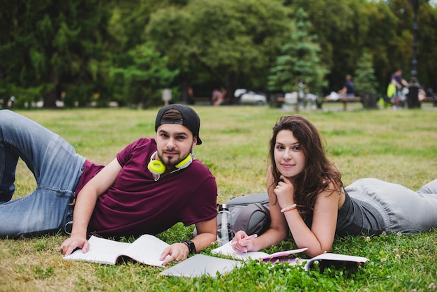 Die Schüler liegen auf dem Gras mit Notebooks