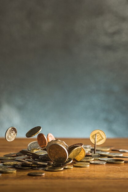 Die Silber- und Goldmünzen und fallenden Münzen auf Holztisch