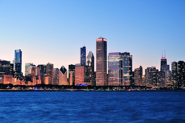 Die Skyline der Innenstadt von Chicago in der Abenddämmerung mit Wolkenkratzern über dem Michigansee mit klarem blauem Himmel.