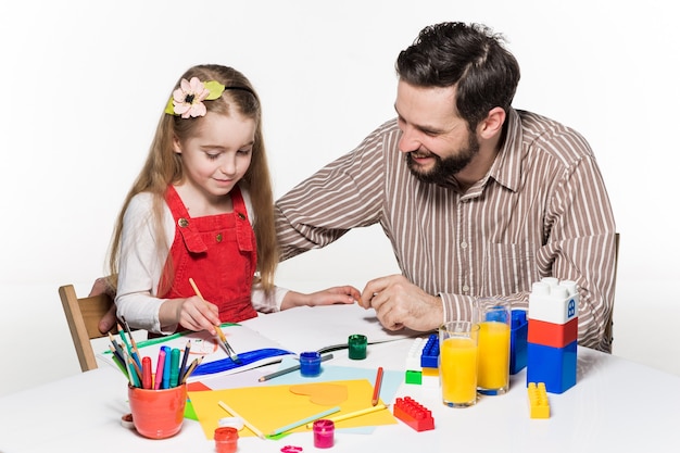 Die Tochter und der Vater zeichnen und schreiben zusammen auf weißem Hintergrund