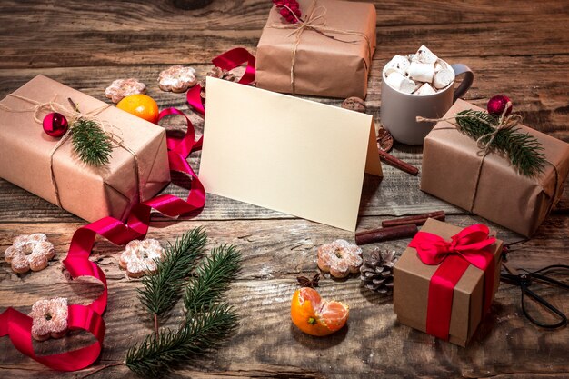 Die Winterkomposition mit Geschenken und Tasse mit Marshmallow