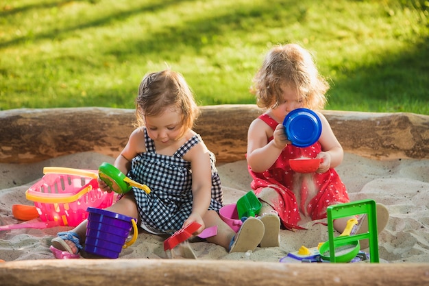 Kostenloses Foto die zwei kleinen mädchen spielen spielzeug im sand