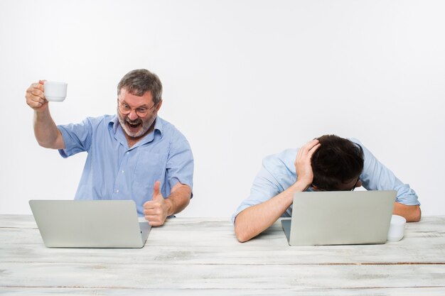 Die zwei Kollegen, die im Büro auf weißem Hintergrund zusammenarbeiten