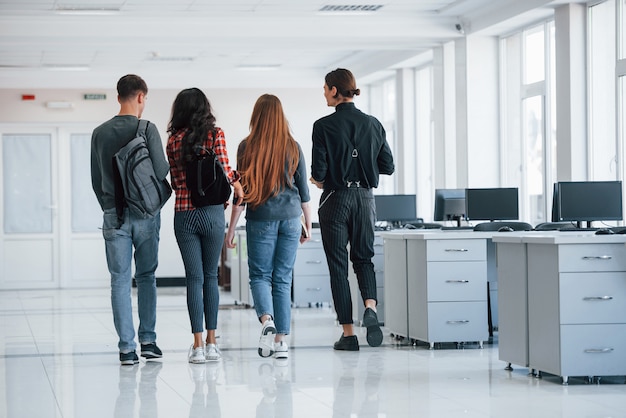 Dieser Raum wird bald leer sein. Gruppe junger Leute, die in ihrer Pausenzeit im Büro gehen