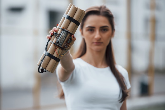 Kostenloses Foto digitale elemente. zeitbombe zeigen. junge frau, die gefährliche explosive waffe in der hand hält