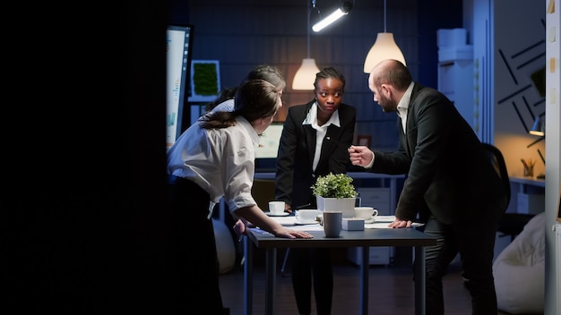 Diverse Geschäftsleute diskutieren über Managementpapiere am Konferenztisch