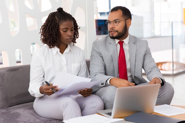 Diverse Mitarbeiter diskutieren Berichte